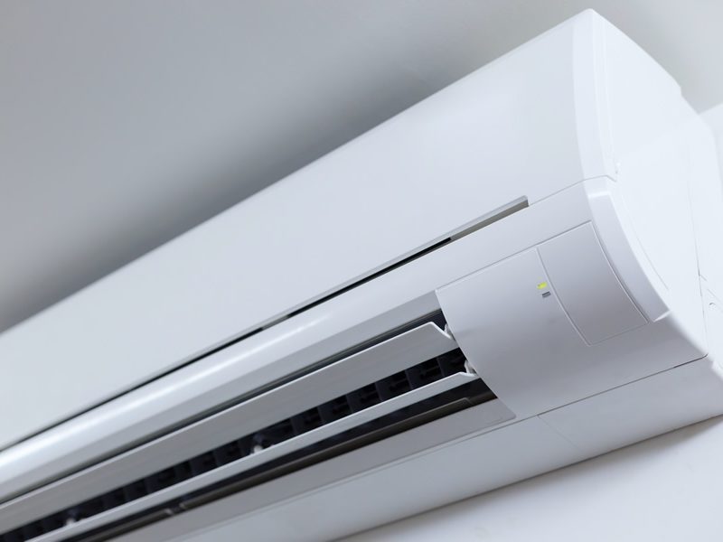 Wall-mounted split air conditioning unit with a sleek white exterior.